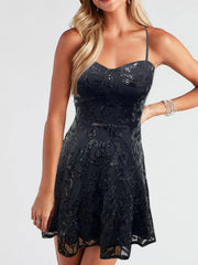 Black sequin mini dress with thin straps and a fitted bodice, close front view on a model.