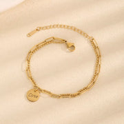 Gold-tone LOVE charm bracelet arranged in a circle with clasp visible