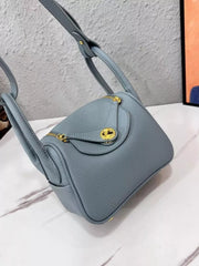Angled view of a blue crossbody bag with flap closure