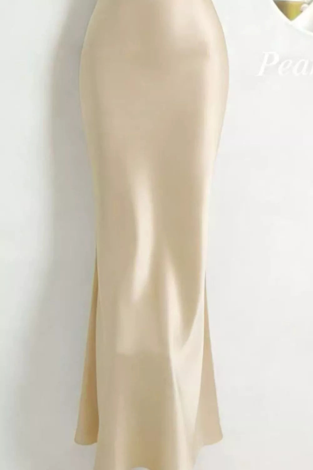 Side view of the cream satin maxi dress showing its fitted silhouette and hem.