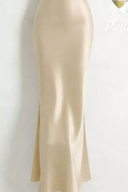Side view of the cream satin maxi dress showing its fitted silhouette and hem.