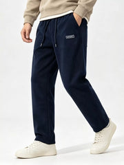 Model walking in navy wide-leg pants showing the loose straight legs and side pocket