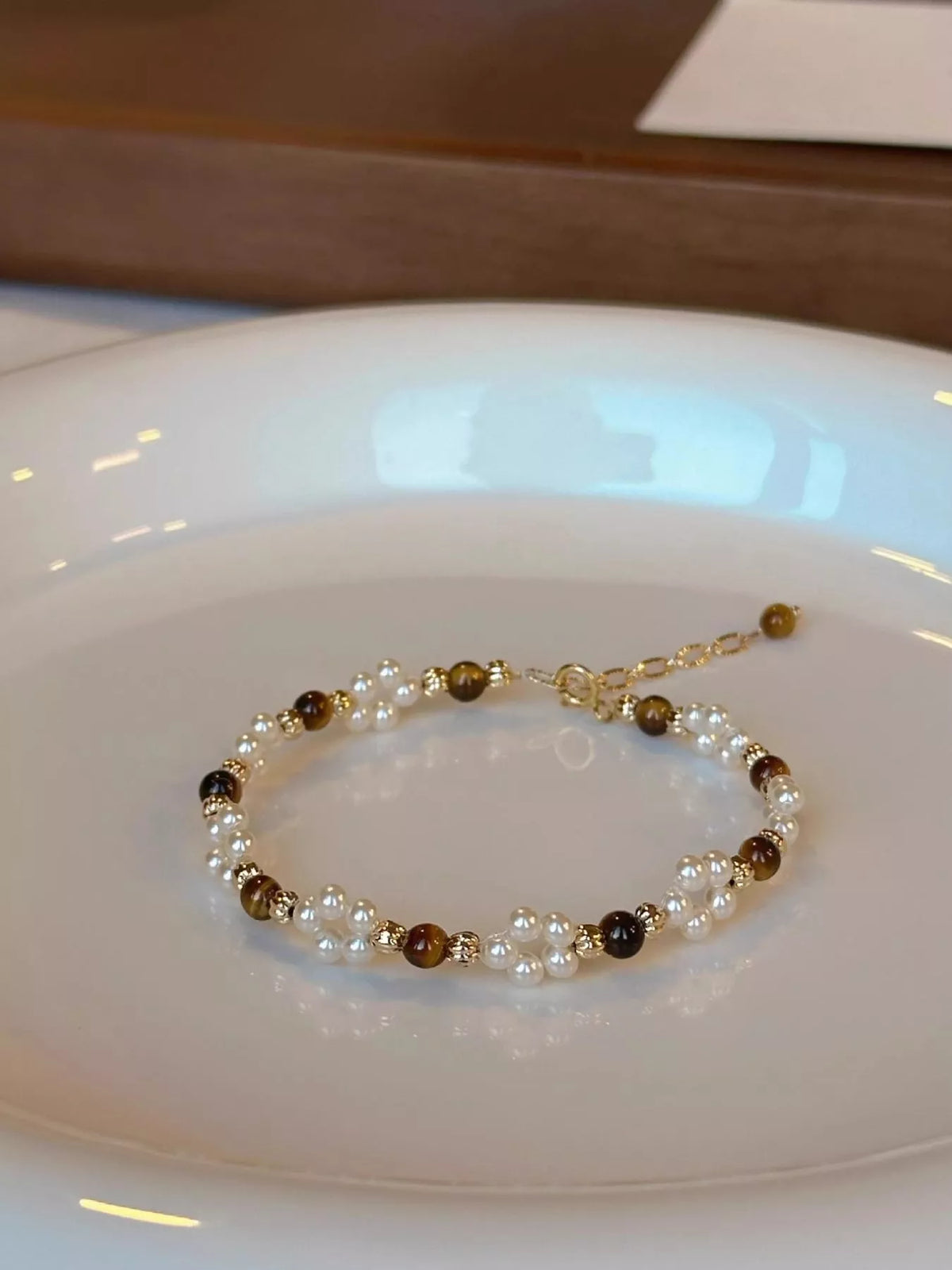 Detail of the tiger eye stone and pearl beads held in hand