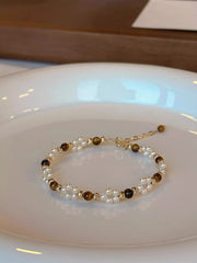 Detail of the tiger eye stone and pearl beads held in hand