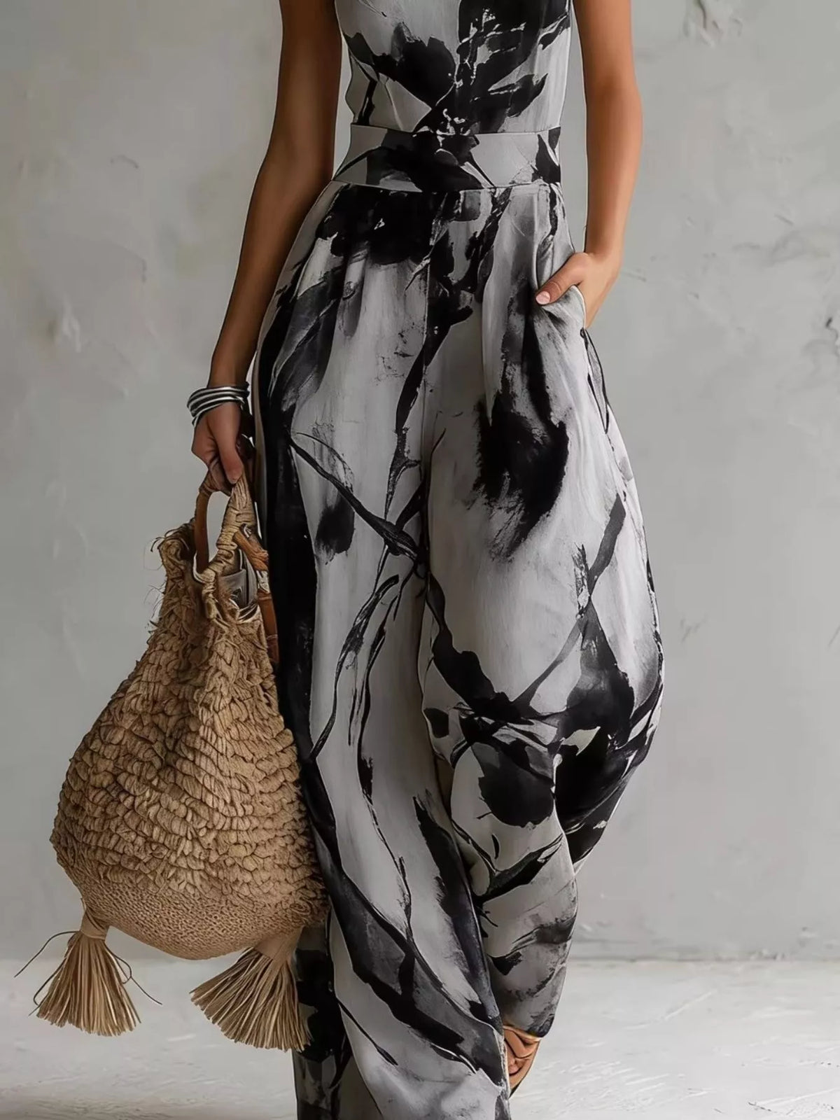 Lower view of the grey and black jumpsuit showing its pocket and wide legs.