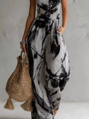 Lower view of the grey and black jumpsuit showing its pocket and wide legs.