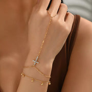 Gold-tone chain bracelet with cross charm worn on the wrist