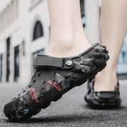 Black printed clog with ventilation holes and instep strap, worn from the side