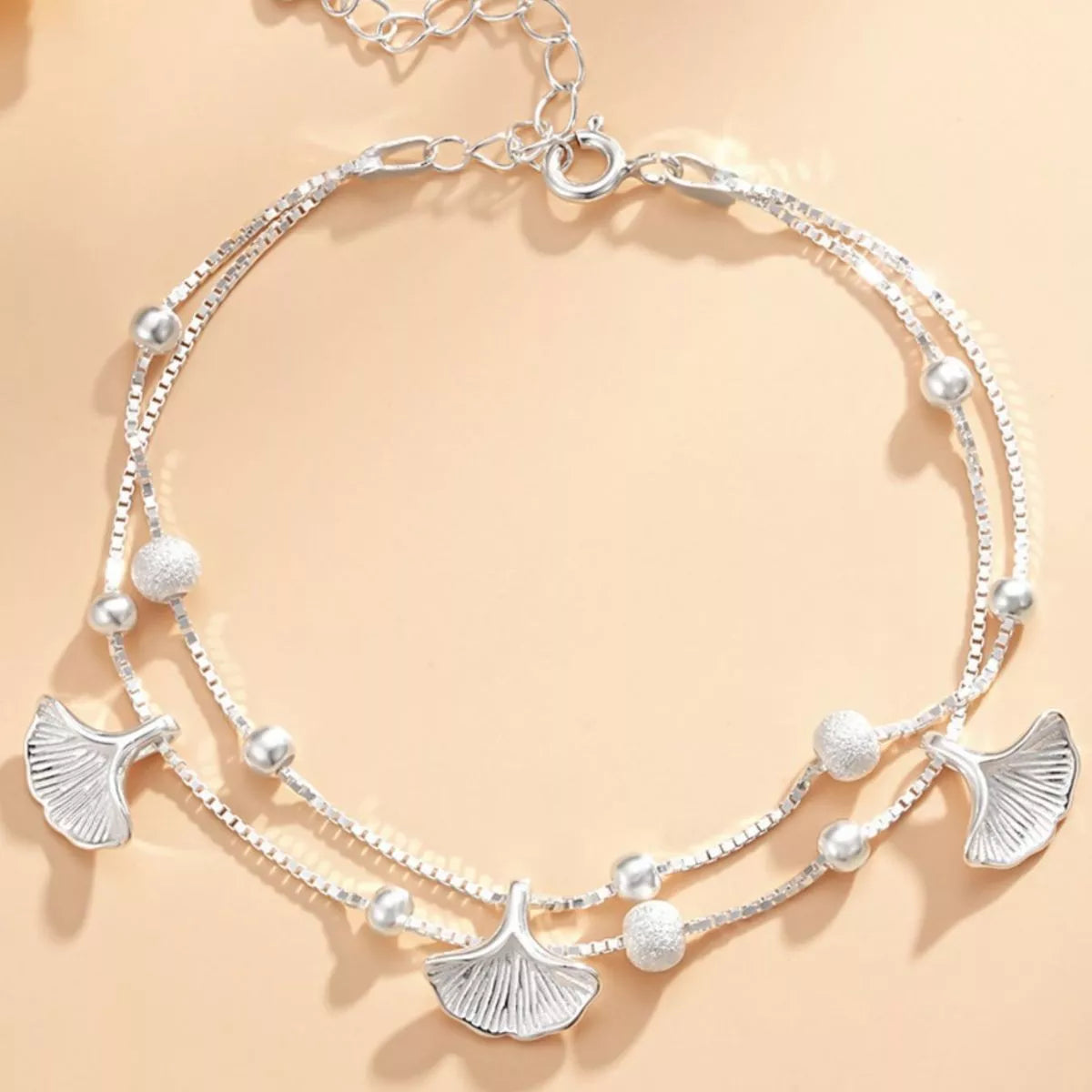 Double-layer silver ginkgo leaf bracelet arranged in a circle with bead accents