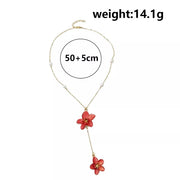 Gold-tone flower pendant necklace with pearl accents and chain length graphic