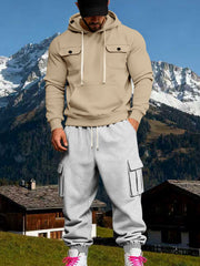 Model facing forward in a beige chest-pocket hoodie and light grey cargo joggers