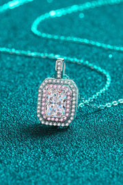 Angled close-up of a pink-bordered rectangular pendant and silver-tone chain