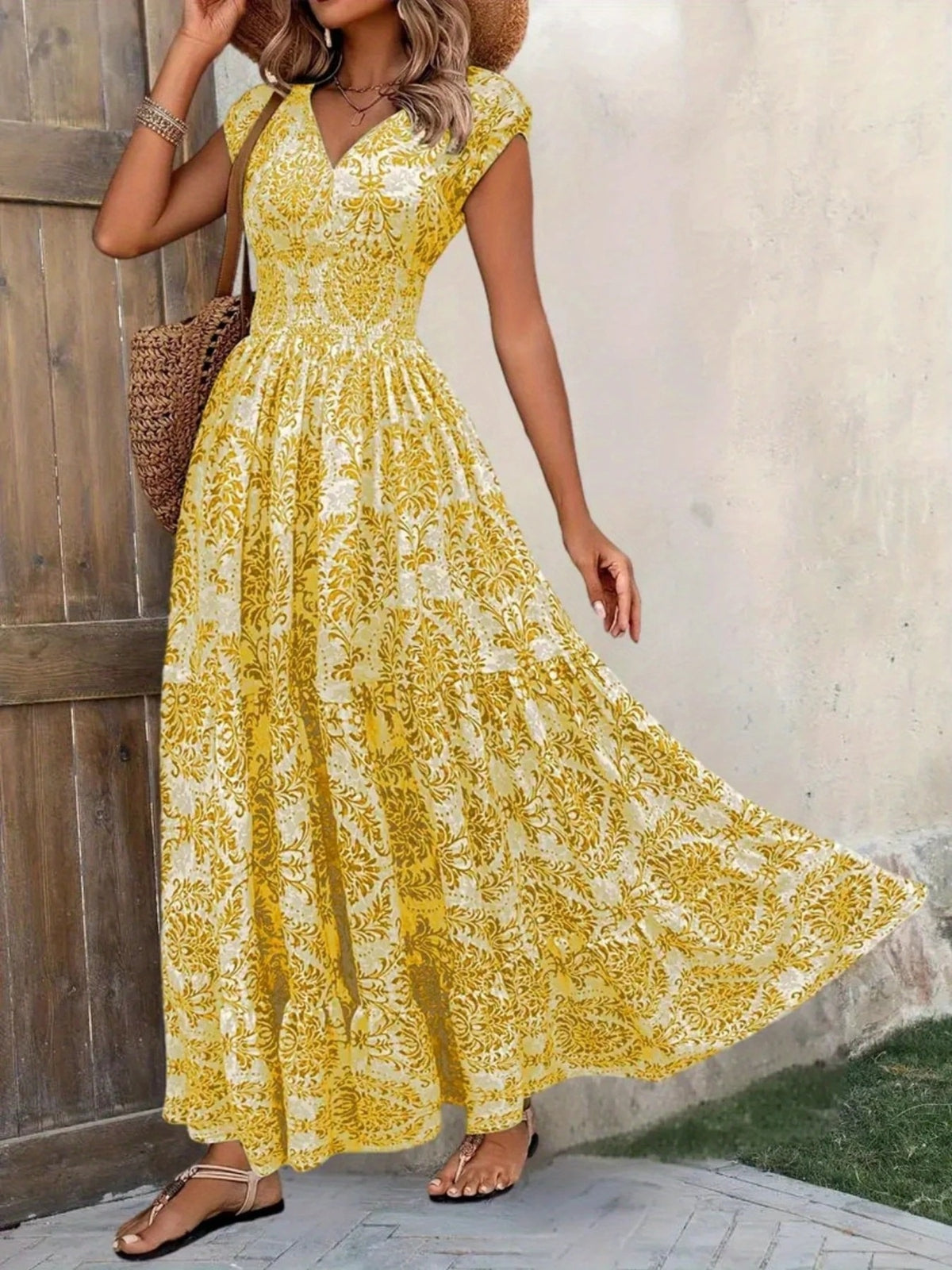 Yellow floral maxi dress with a high slit, modeled with one side of the skirt lifted.