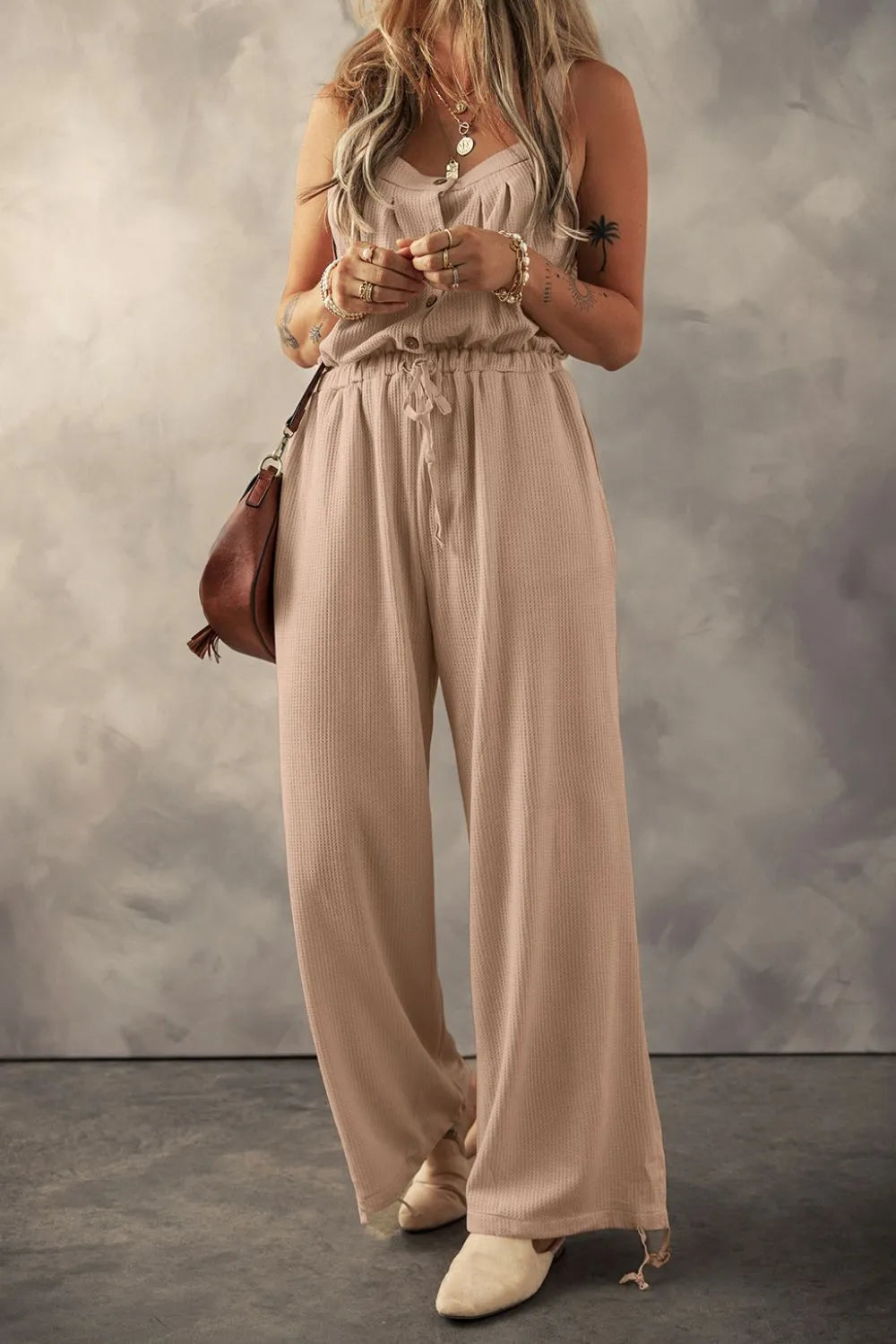 Khaki textured jumpsuit, model full-length front view holding phone