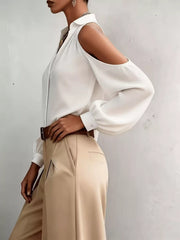 Side view of white blouse with shoulder cutout and flowing sleeve.