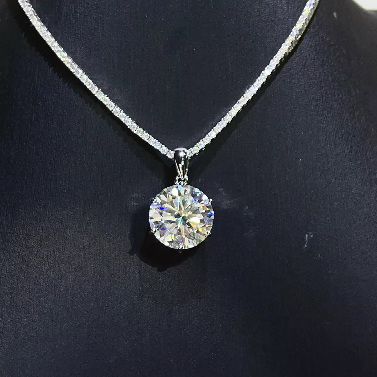 Round brilliant moissanite pendant necklace displayed against a dark background