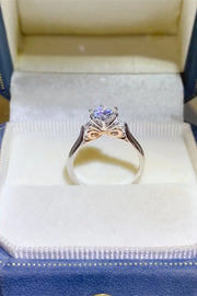 Purple-stone ring standing upright inside a cream-lined ring box