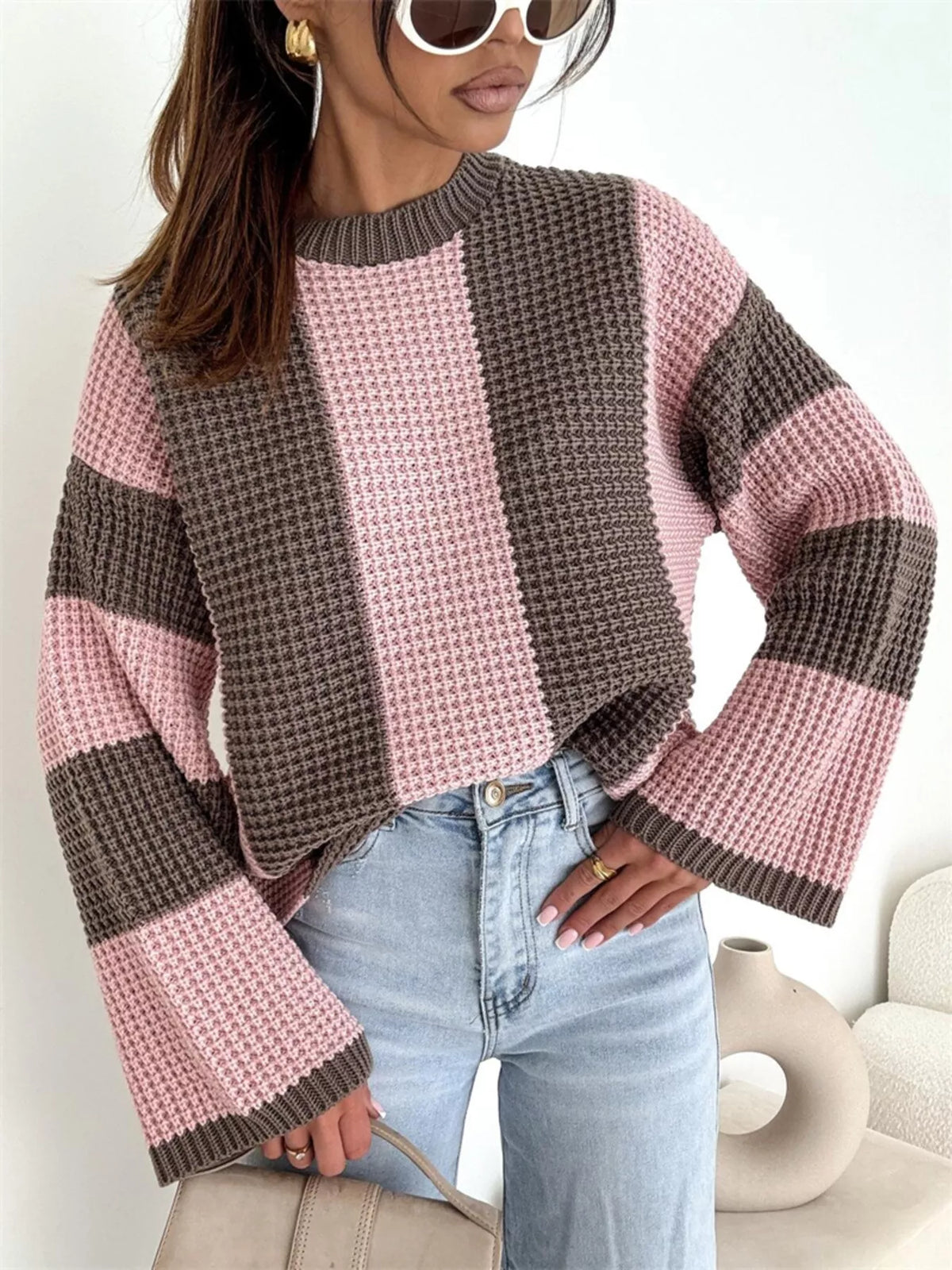 Model wearing a pink and brown oversized sweater with broad colour-block stripes