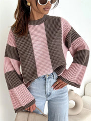 Model wearing a pink and brown oversized sweater with broad colour-block stripes