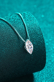 Close-up of marquise-cut moissanite pendant on teal fabric