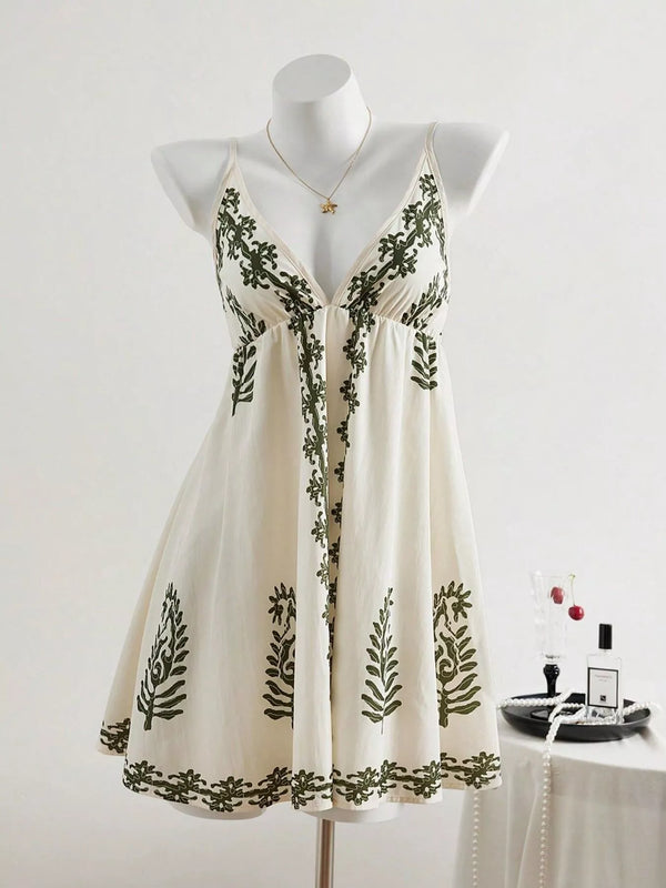 Ivory sleeveless V-neck mini dress with dark botanical embroidery displayed on a mannequin
