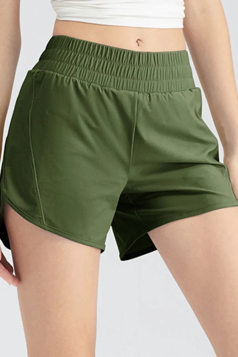 Close-up front view of dark green shorts with a gathered waistband