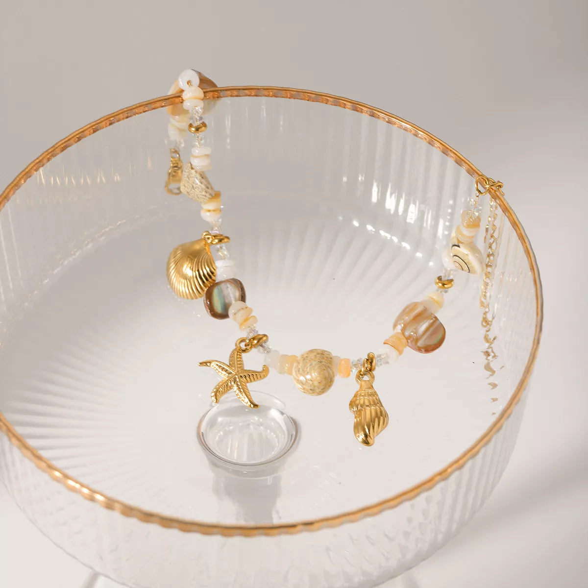 Gold shell charm bracelet laid flat