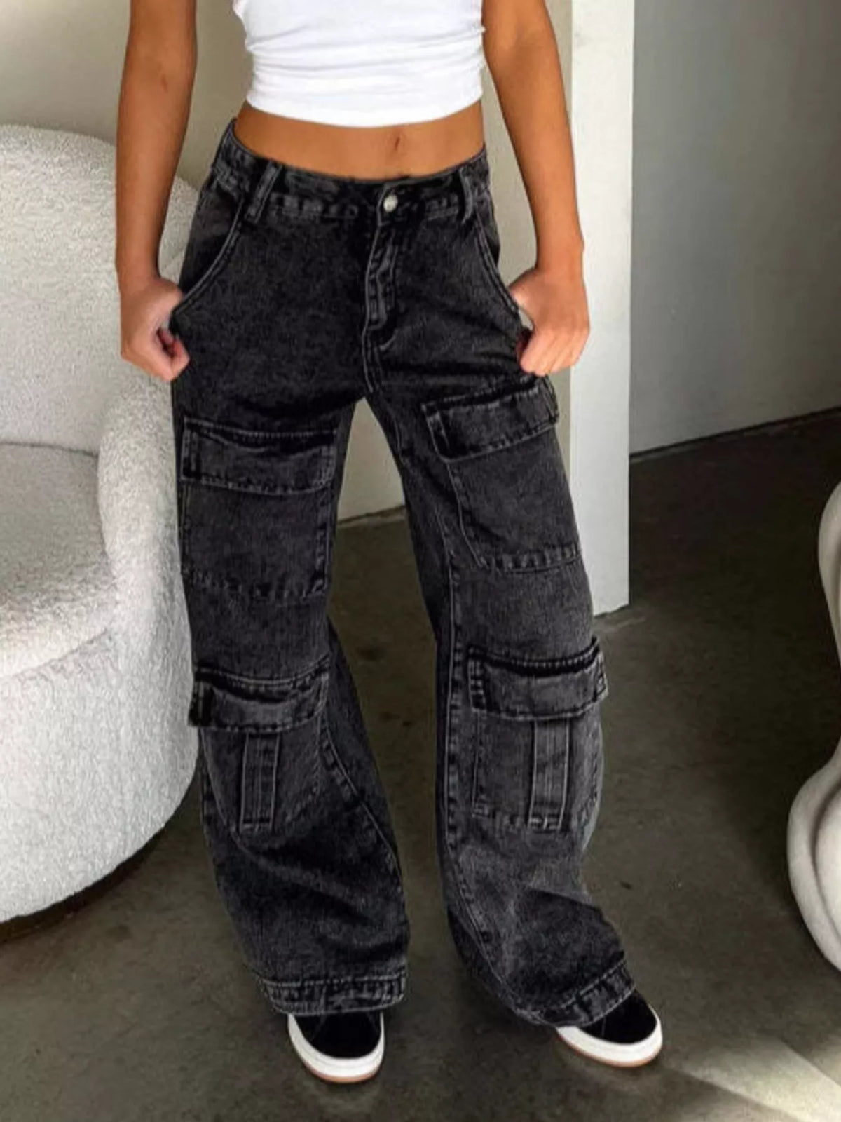 Acid-wash black cargo jeans modeled with wide legs and multiple pockets