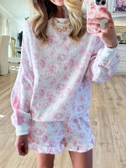 Front mirror view of pink floral sweatshirt and ruffle-hem shorts