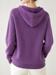 Back view of the purple knit sweater showing its hood and ribbed hem.