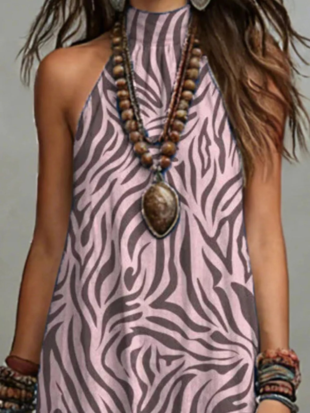 Close view of the mauve zebra-like print and halter neckline on the maxi dress.