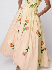 Closer view of the peach floral dress bodice and gathered skirt on a model.