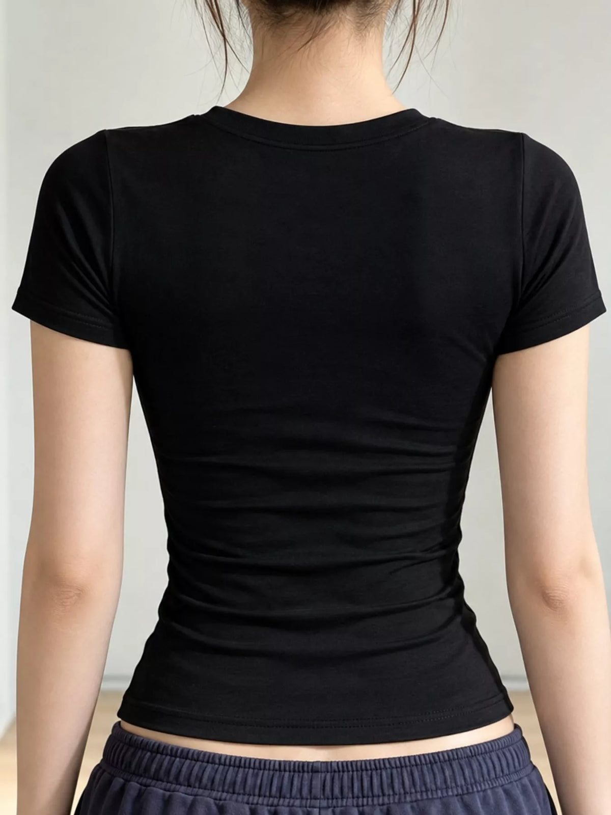 Black short-sleeve crew-neck T-shirt, back view on model