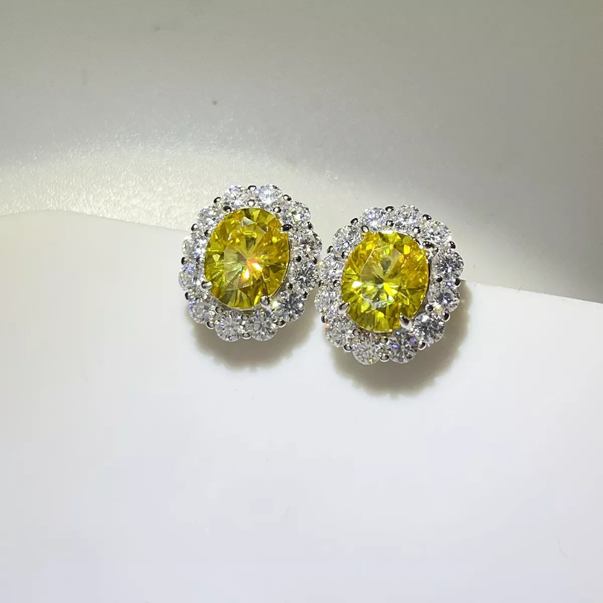 Close-up of the yellow centre stones and clear halo settings on the earrings.