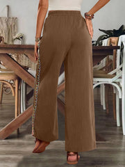 Back view of brown embroidered stripe pants