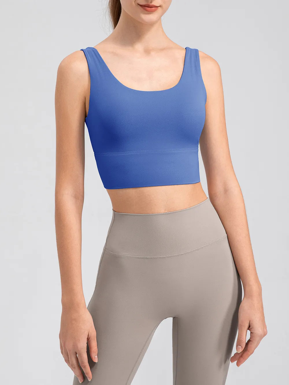 Model wearing the blue scoop-neck tank with leggings, front view