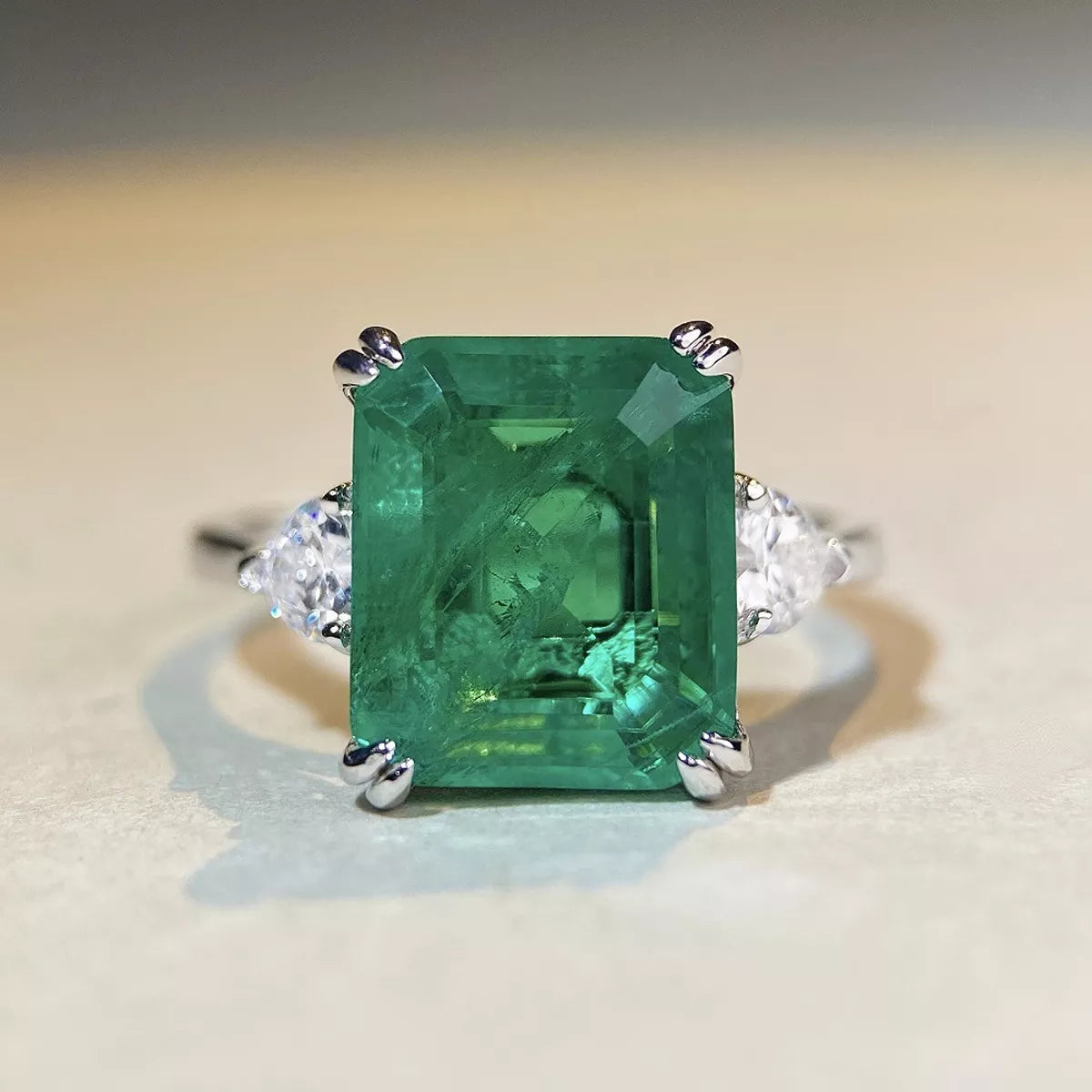 Close-up of the green rectangular stone and silver prongs.