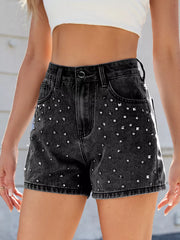 Black high-waisted denim shorts with silver-coloured studs across the front