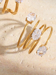 Stacked gold-tone open ring with clear oval stones worn on hand