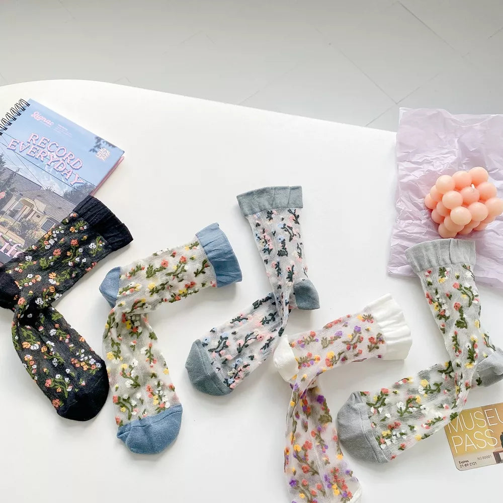 Five floral sheer socks displayed in a loose arrangement
