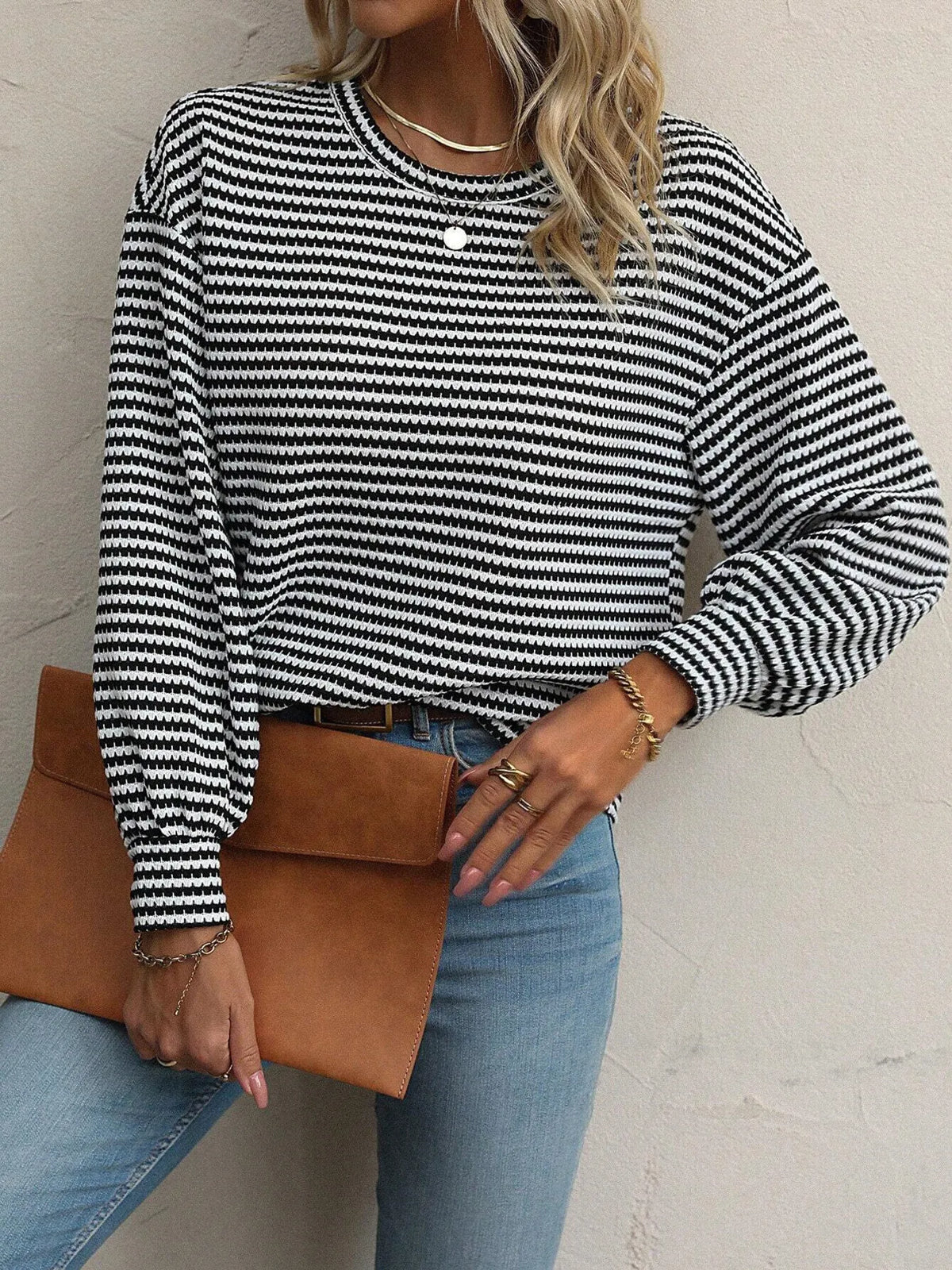 Close view of round neckline and stripes on black top