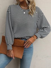 Close view of round neckline and stripes on black top