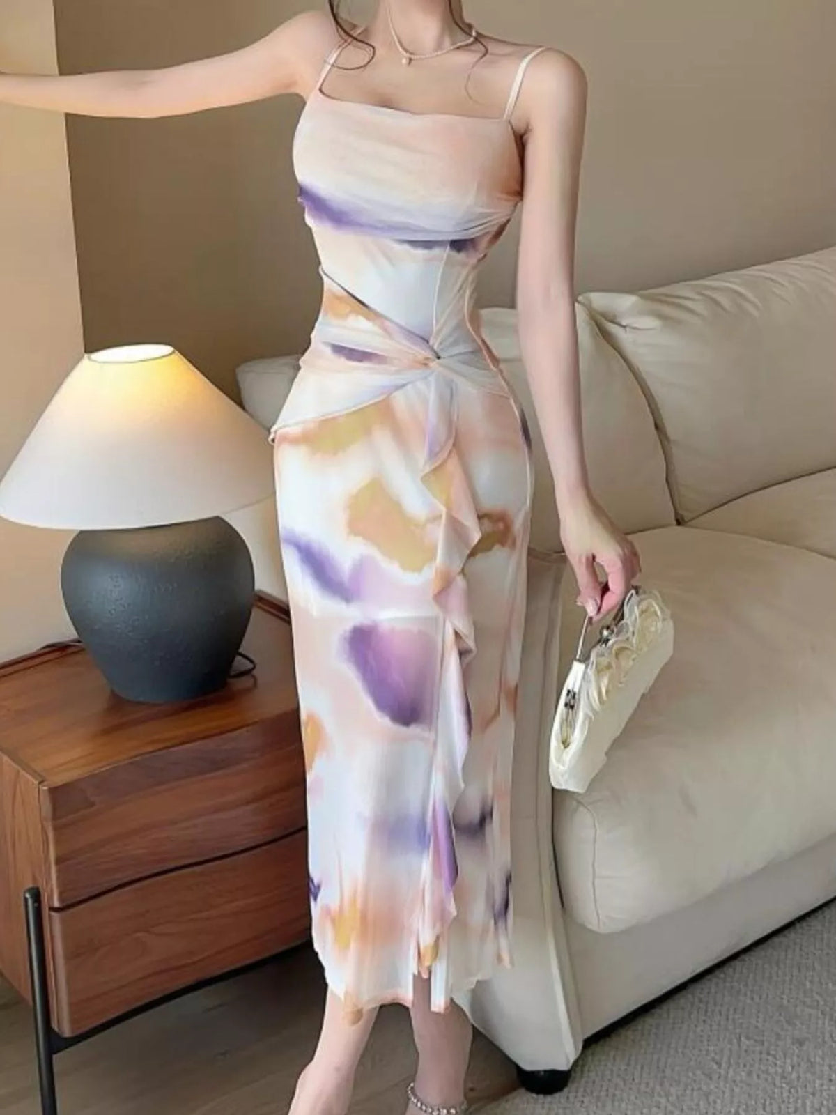 Three-quarter view of the pastel watercolor-print ruched midi dress with thin straps.