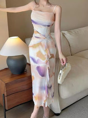 Three-quarter view of the pastel watercolor-print ruched midi dress with thin straps.