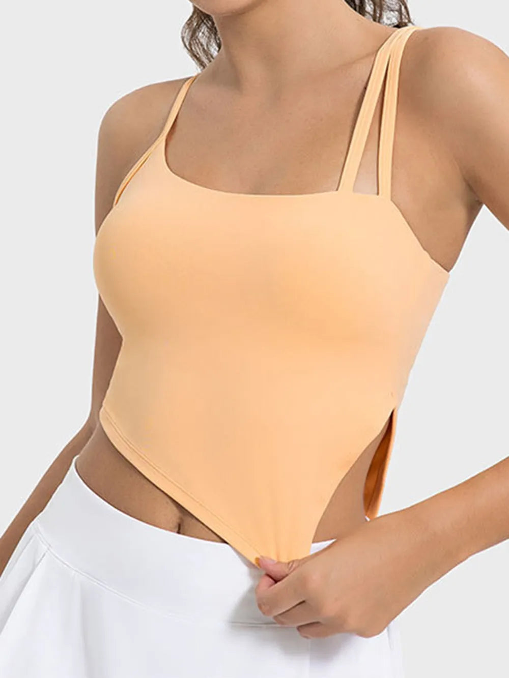 Peach asymmetrical-neck workout cami modeled from the front