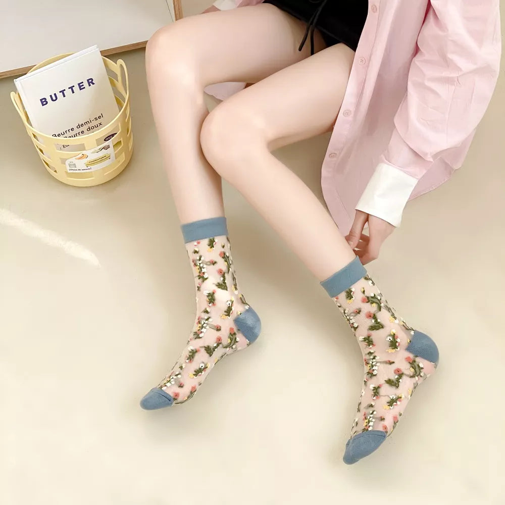 Light floral sheer socks with blue-gray cuffs and toes worn on legs