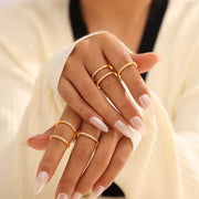 Close view of gold-tone zircon ring worn on crossed fingers