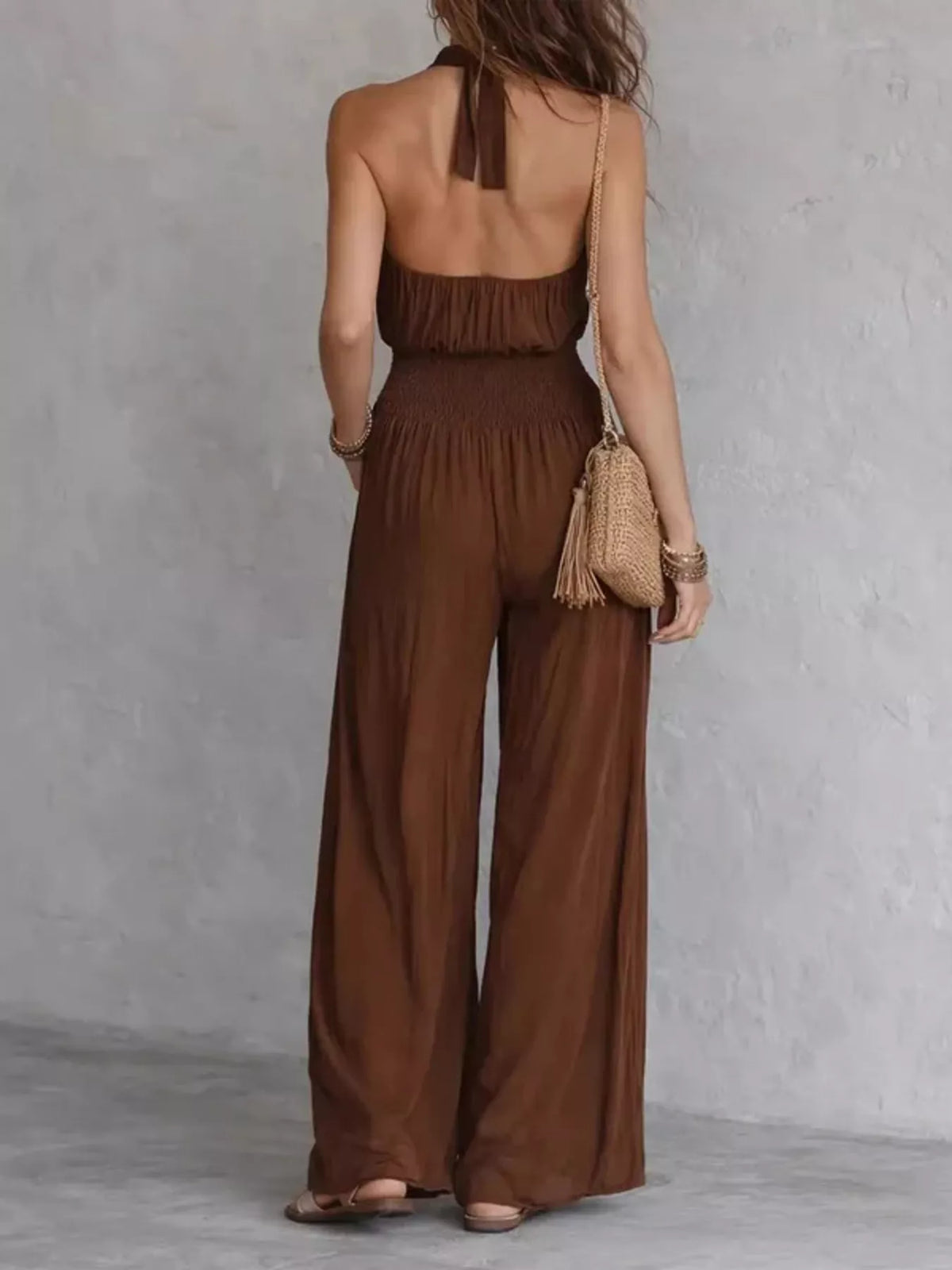 Back view of brown halter jumpsuit with open upper back and wide legs