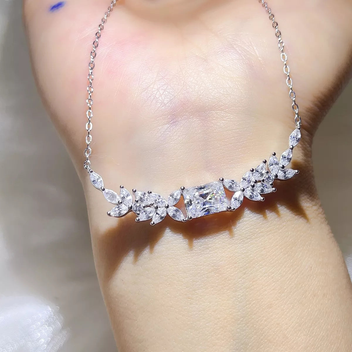 Close-up of the floral moissanite pendant and stone details