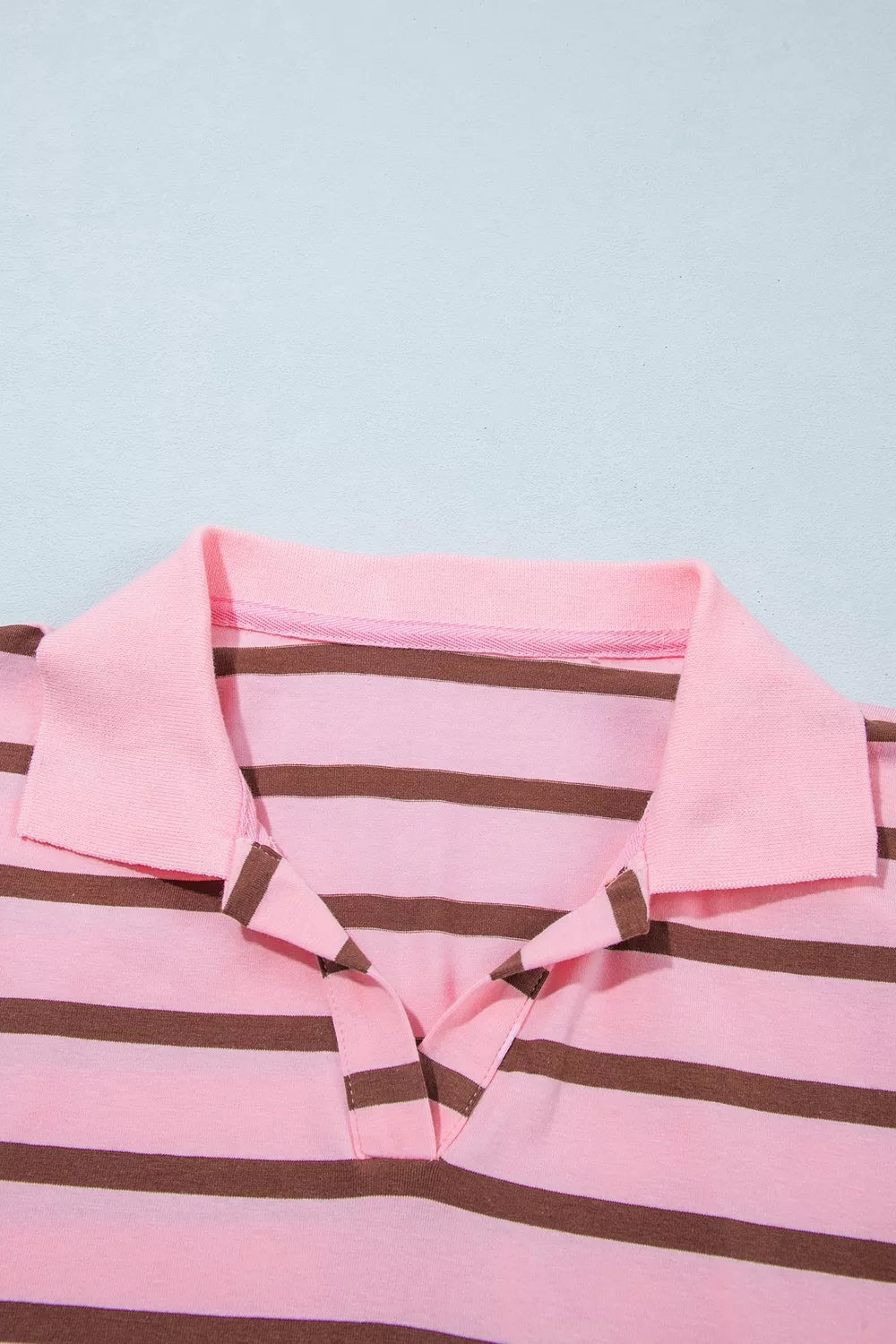 Close-up of striped shirt collar and top buttons.